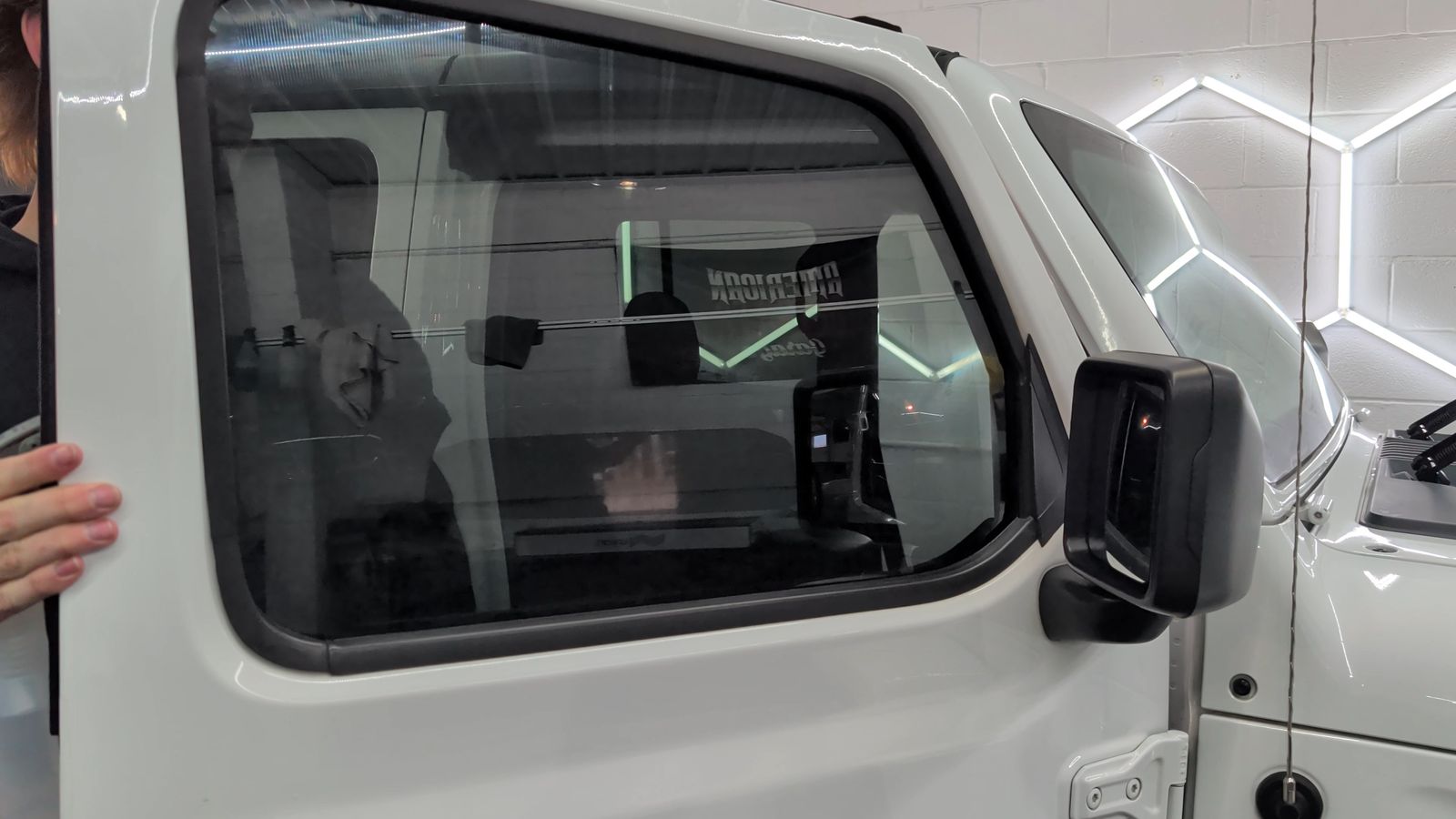 Finished ceramic-tinted door glass on a white Jeep, door open, in the Taggart Films bay