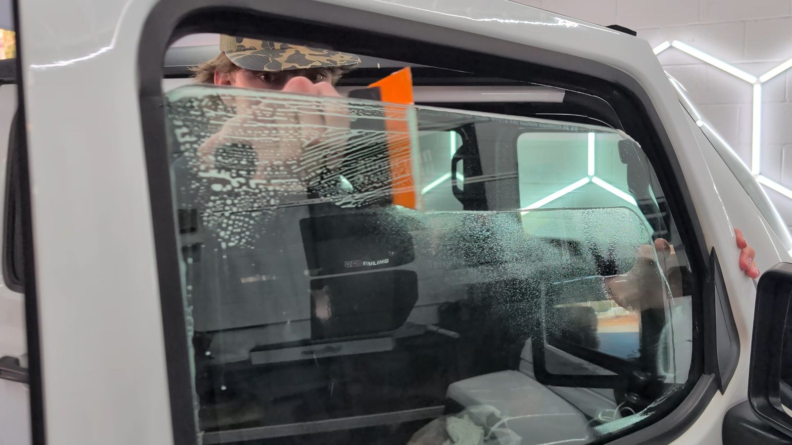 Installer looking through soapy door glass while ceramic film is laid at Taggart Films